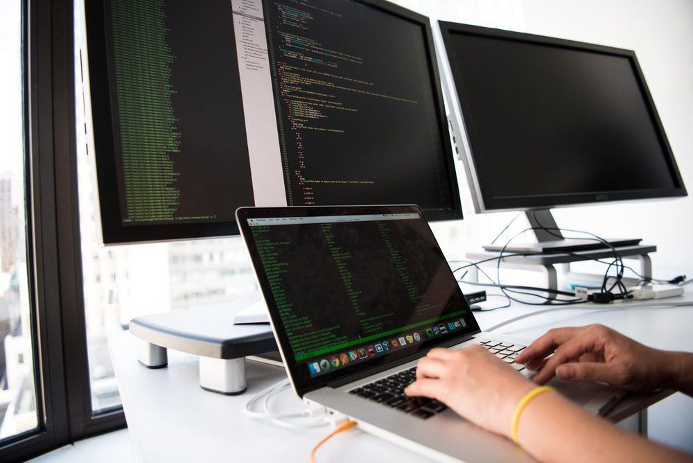 Weavtech engineer working at a multi-monitor workstation